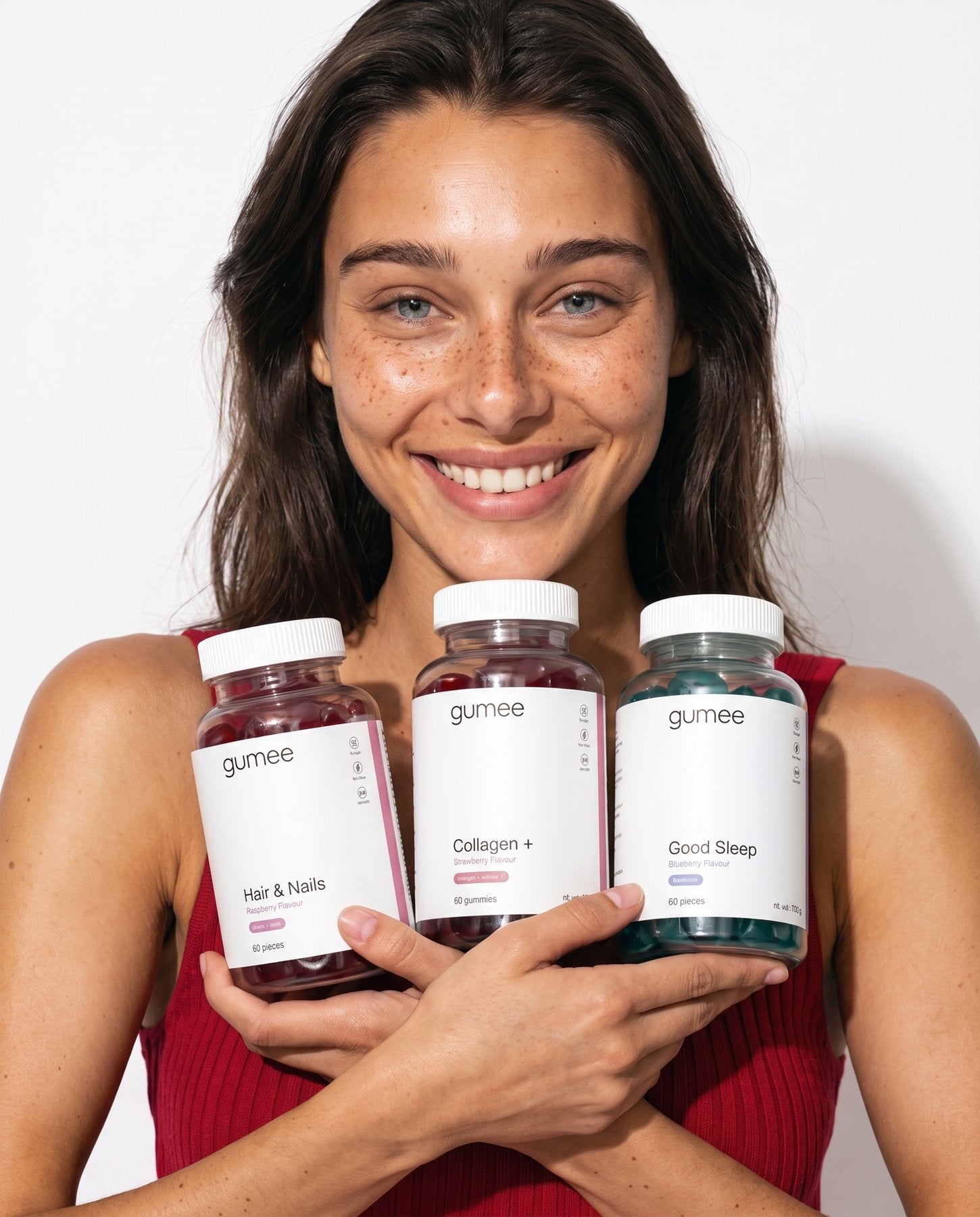 A smiling customer holding the three gumee jars: Good Sleep, Collagen + and Hair & Nails